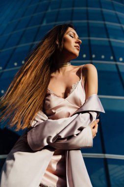 Seksi bir kız bir ceket ve iç çamaşırı iş merkezinde kentin moda portre. Kent merkezinde.