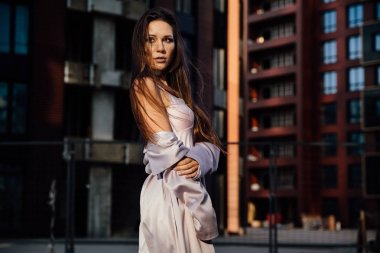 Seksi bir kız bir ceket ve iç çamaşırı iş merkezinde kentin moda portre. Kent merkezinde.