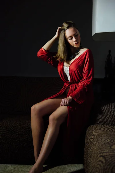 Szép szexi hölgy elegáns piros köntöst. Divat modell beltéri portréja. — Stock Fotó