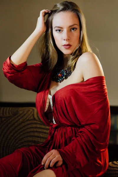 エレガントな赤いローブの美しいセクシーな女性。屋内モデルのファッション ポートレート. — ストック写真