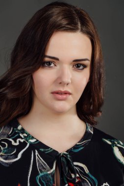 Ayrıca gündelik elbise giyim moda model boyut. gri studio arka plan üzerinde şişman kadın.