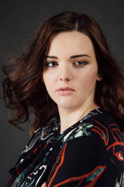 Ayrıca gündelik elbise giyim moda model boyut. gri studio arka plan üzerinde şişman kadın.