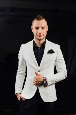 kıllar ve bir mendil ile beyaz elbiseli şık adam. Stüdyo ptrait karanlık bir arka plan üzerinde.