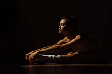 Kusursuz bir beden ile güzel modern bale dansçısı studio koridorda katta oturur.