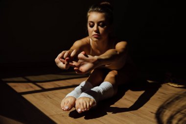 Kusursuz bir beden ile güzel modern bale dansçısı studio koridorda katta oturur.