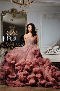 Stüdyo piyano şık bir iç tasarıma poz bulut elbiseli güzel seksi esmer.