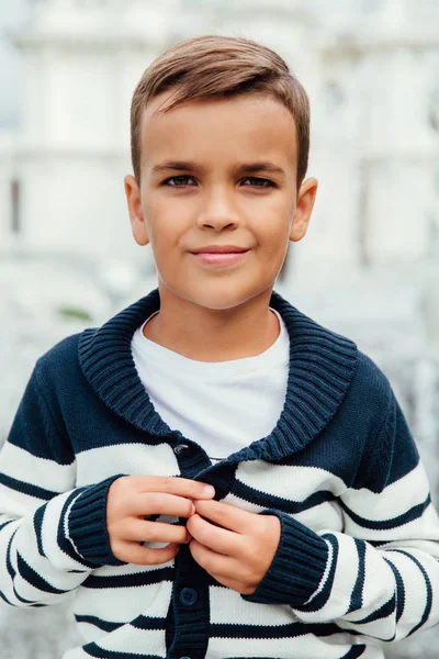 Gros plan portrait d'un jeune élève d'un écolier. Souriant montrant pull à rayures . — Photo