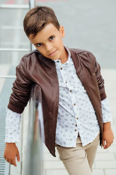 Adolescent garçon attend les escaliers à la rampe. Enfant à la mode dans des vêtements de ville élégants . — Photo