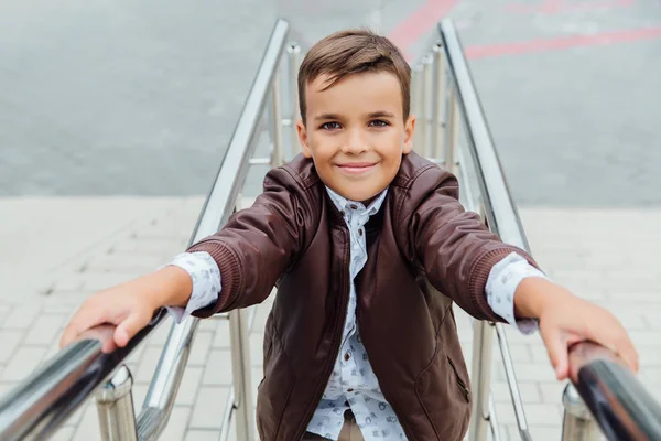 O adolescente está à espera das escadas do corrimão. Criança na moda em roupas de cidade elegantes . — Fotografia de Stock