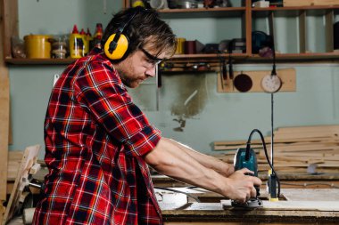 El ile el freze tezgahı doğrama atölyesinde çalışan bir marangoz. marangoz.