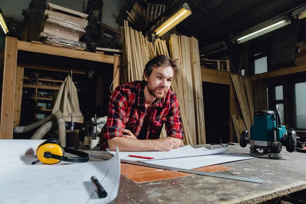 Homme faisant un projet de plan à l'aide d'un crayon sur la table avec atelier sur fond . — Photo