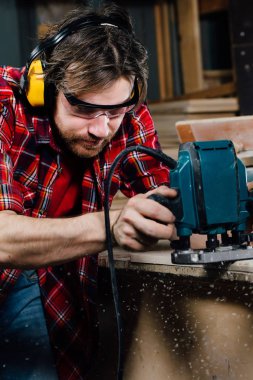 El ile el freze tezgahı doğrama atölyesinde çalışan bir marangoz. marangoz.