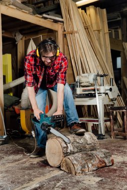 marangoz atölyesinde bir elektrikli testere ile ağaç testereleri. Testere sürecinde marangoz.