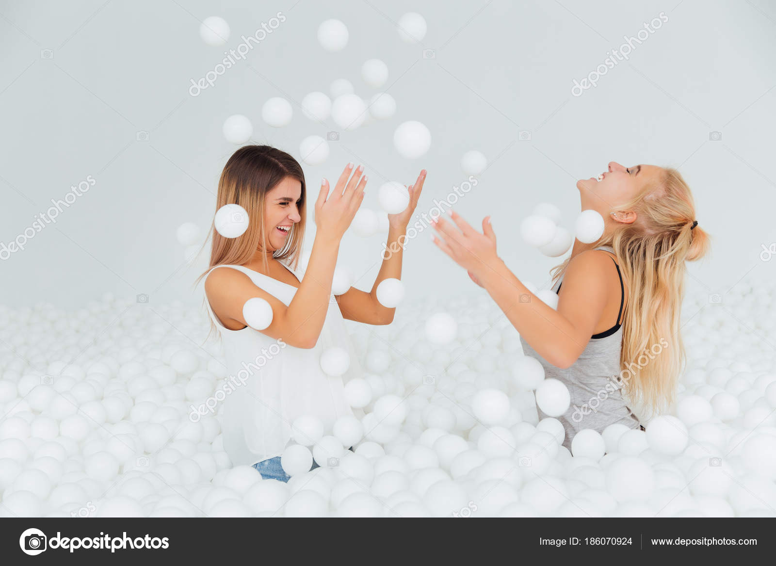 세로 행복 여자 친구 서 마른 풀에 흰색 플라스틱 볼에 둘러싸여. — 스톡 사진 © photominus #186070924