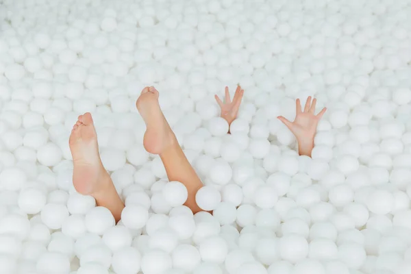 Kadın vücut parçaları kuru havuzda beyaz plastik toplar dışarı sopa. Kopya splace. — Stok fotoğraf