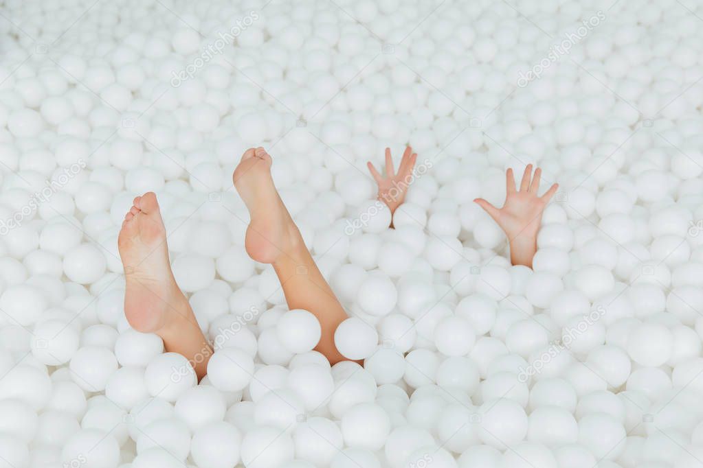 partes del cuerpo de la mujer sobresalen bolas de plástico blanco en la