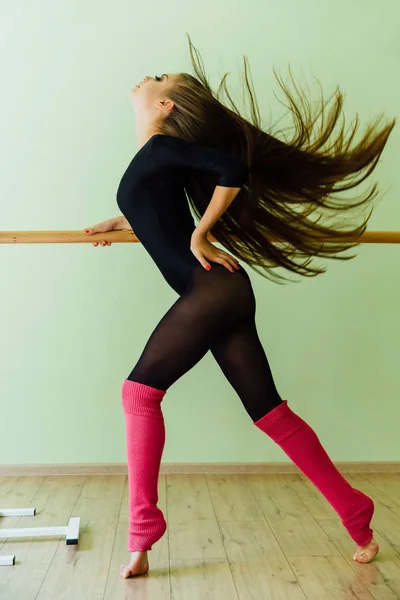 Unga vackra dansare poserar i studio wit balett bar på tå. Moderna sexig brunett. — Stockfoto