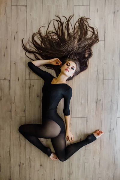 Красивая молодая модель балетной танцовщицы лежит на полу. Вид сверху . — стоковое фото