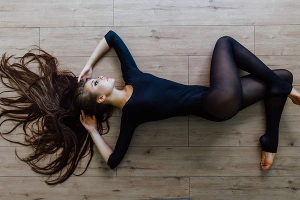 Belle jeune danseuse de ballet modèle couchée sur le sol. Vue du dessus . — Photo