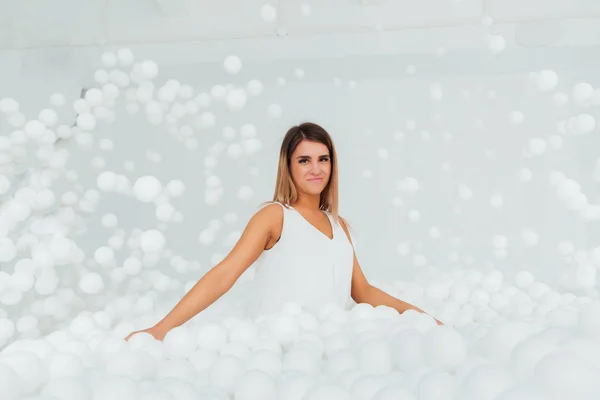 Mutlu kadın portre hazır kuru havuzda beyaz plastik topları tarafından çevrili. Kopya splace. — Stok fotoğraf