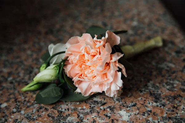 Boutonniere, flor buraco botão, um creme peônias na mesa de granito . — Fotografia de Stock