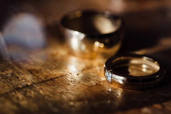 두 아름 다운 황금 결혼 반지와 귀걸이 나무 배경. — 스톡 사진