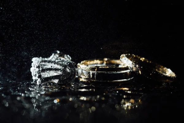 Wedding rings and earrings are wet, with drops. Reflections on the glass are professional. — Stock Photo, Image