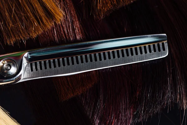 Professionele schaar stylist kapper op de achtergrond van de gezonde mooie haren. Een voorbeeld van een tester. — Stockfoto