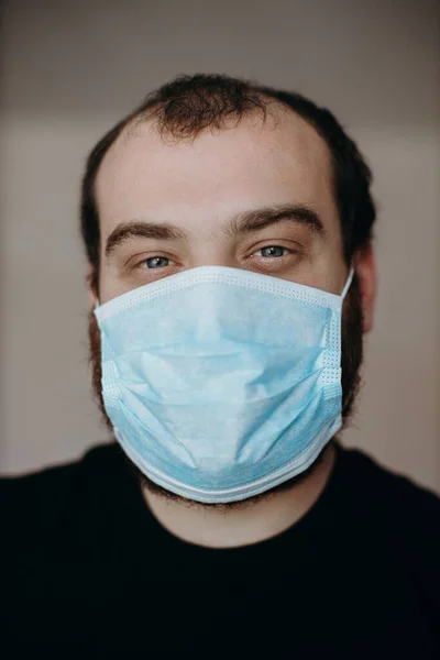 Retrato del hombre que usa una mascarilla médica protectora para prevenir la infección del coronavirus . Fotos De Stock