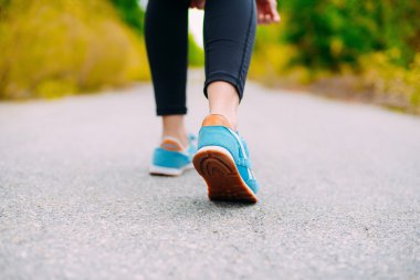 Kadın spor ayakkabı ayaklarda. Sporcumuz önce onun ayakkabı bağcığı bağlama