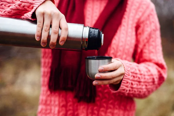 Viaggiatore ragazza versando il tè dalla tazza thermos, all'aperto. Giovane donna — Foto Stock