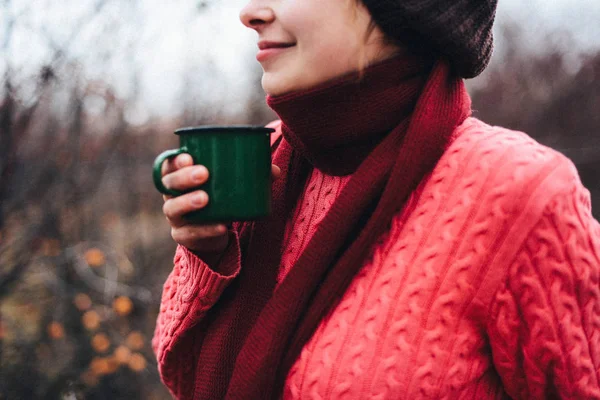 Traveler girl pouring tea from thermos cup, outdoors. Young woma