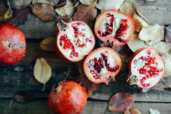 Ripe pomegranate fruit on wooden vintage background. Red juice p