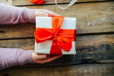  Sevgililer günü kavramı. Ahşap backg üzerinde kırmızı fiyonklu hediye paketi