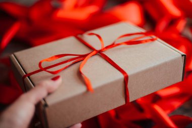 Sevgililer günü kavramı. Ahşap backgr üzerinde kırmızı fiyonklu hediye paketi