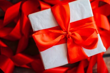 Sevgililer günü kavramı. Ahşap backgr üzerinde kırmızı fiyonklu hediye paketi