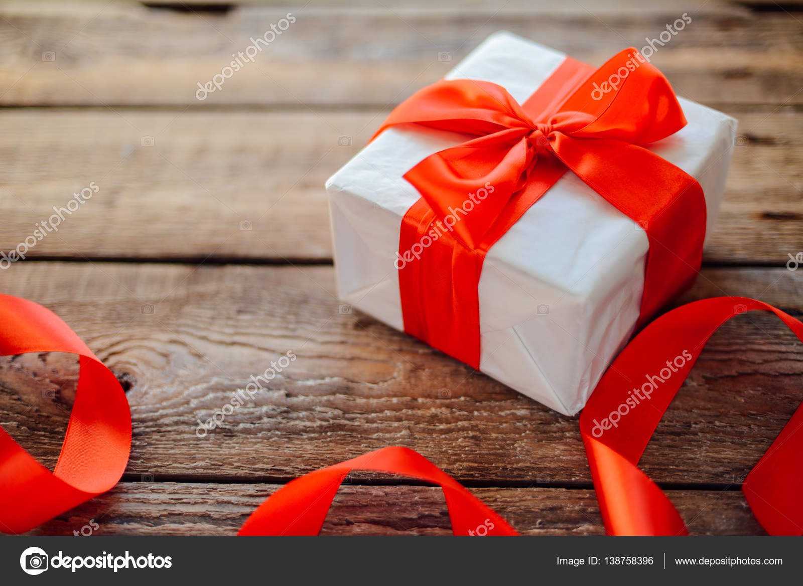 Valentine's Day concept. Gift with red bow on the wooden backgr Stock Photo  by ©ch_ch 138758396
