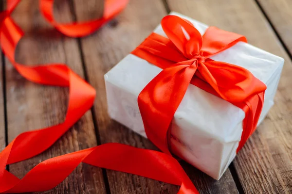 Valentine's Day concept. Gift with red bow  on the wooden backgr Stock Photo