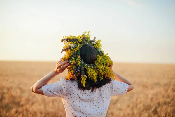 Beautiful girl in wreath of flowers in meadow on sunny day. Port — Stock Photo, Image