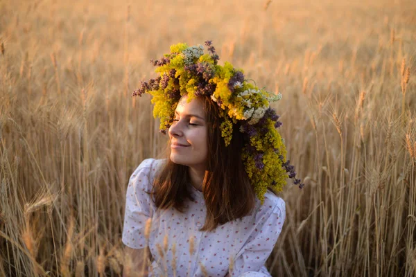 Beautiful girl in wreath of flowers in meadow on sunny day. Port — Stock Photo, Image