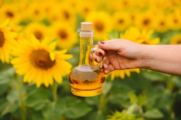 Solrosolja i glasflaska med solros fält på backg — Stockfoto