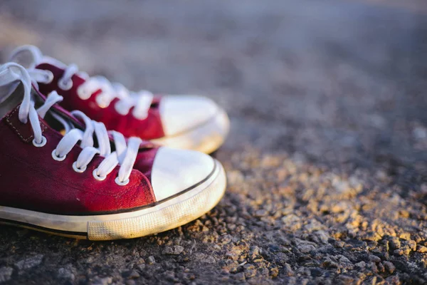 Sneakers på vägen. vägen. röda sneakers på asfalt, ovanifrån. — Stockfoto