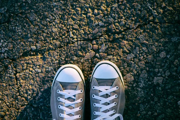 Sapatilhas na estrada. Estrada. tênis vermelhos no asfalto, vista superior . — Fotografia de Stock