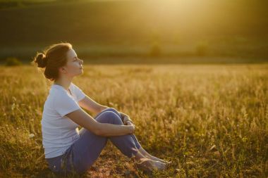 kadın yoga uygulamaları ve lotus pozisyonu üzerinde derin derin düşünür 