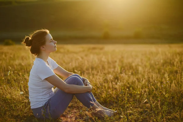 Woman practices yoga and meditates in the lotus position on the — Stock Photo, Image