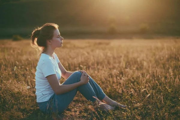 Woman practices yoga and meditates in the lotus position on the — Stock Photo, Image