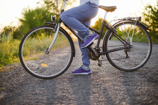 Menina bonita em andar de bicicleta ao ar livre na estrada. Bem-estar um — Fotografia de Stock