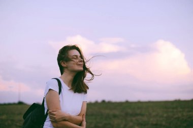 Genç kadın rahatlatıcı yaz günbatımı gökyüzü açık. İnsanlar freedo