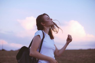 Genç kadın rahatlatıcı yaz günbatımı gökyüzü açık. İnsanlar freedo