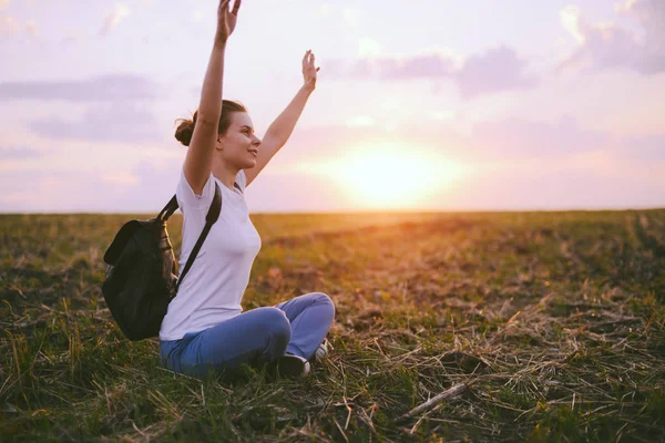 Genç kadın rahatlatıcı yaz günbatımı gökyüzü açık. İnsanlar freedo